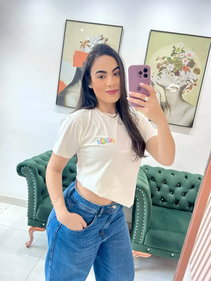 Modelo de t-shirt branca e jeans tirando foto no espelho
